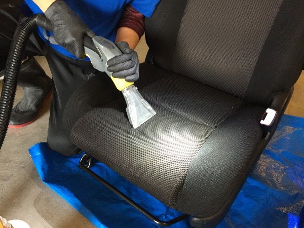 業務用リンサーで、シートの中から汚れを吸い出しているところ