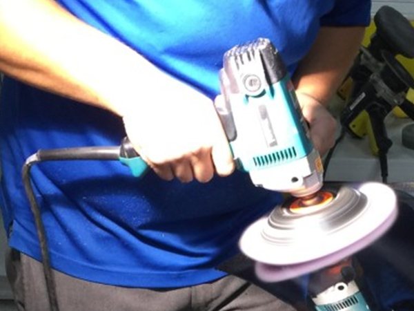 練習用の黒いボンネットをポリッシャーで研磨しているところ