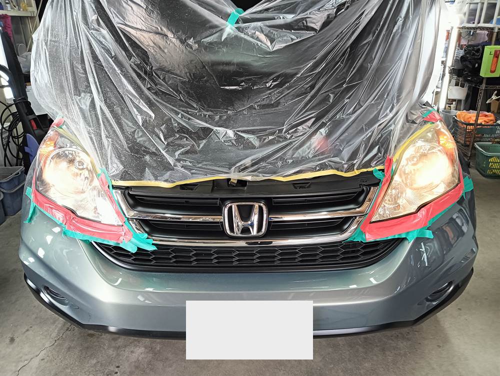 研磨に入る前に、ヘッドライトのまわりをテープで、ボンネットをシートで保護したホンダ CR-V