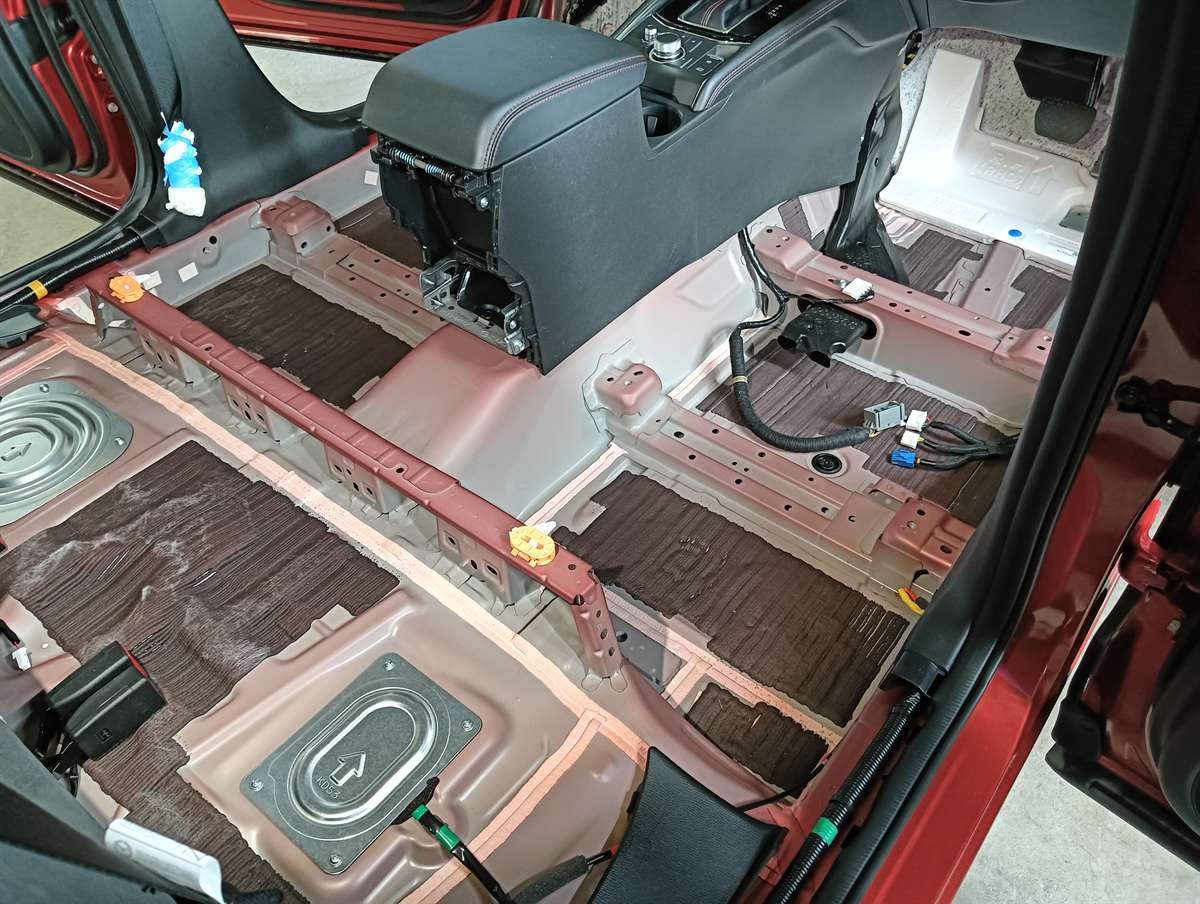 シートとカーペットを外したマツダ CX-5 の車内。床の鉄板が見えている