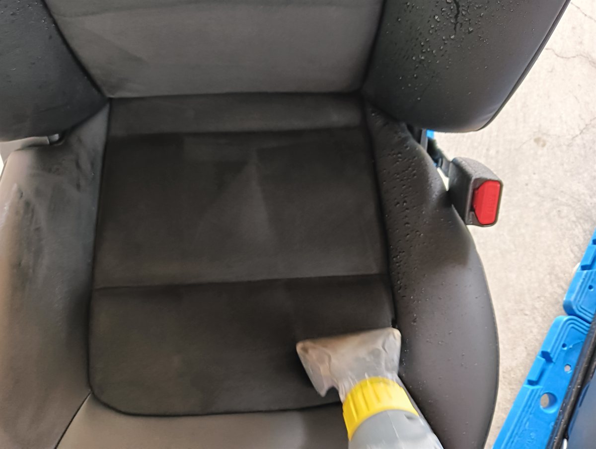 車から外したシートの座面を機械で洗っているところ