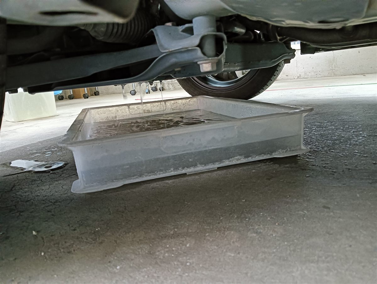 エバポレーターを洗った水を車の下の排水口から受けているところ
