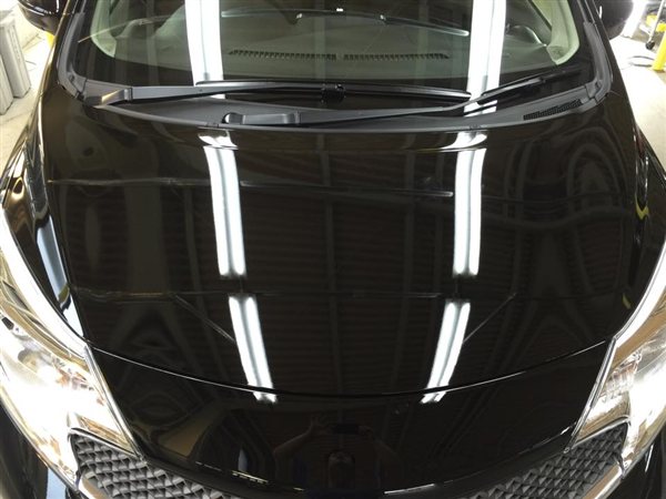 得洗隊でボディコーティングを施工した日産 ノートのボンネット。天井の照明が映り込んでいる（2015年の施工事例）