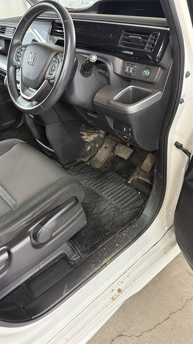 作業前のステップワゴンの運転席の足元。マットに泥汚れがたまっている