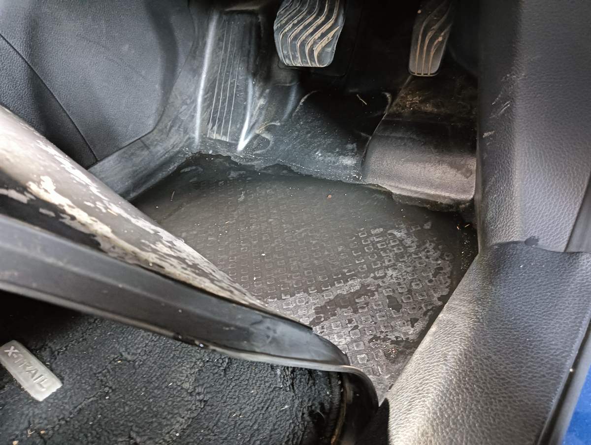 お預かりしたときの日産エクストレイルの運転席の足元。マットの上に水がたまっている