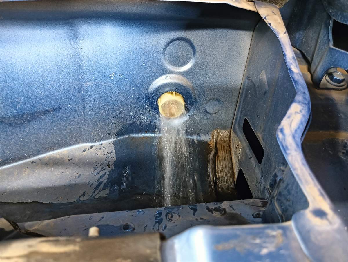 詰まりを取ったサンルーフのドレンホースの出口から、水が流れ出ているところ