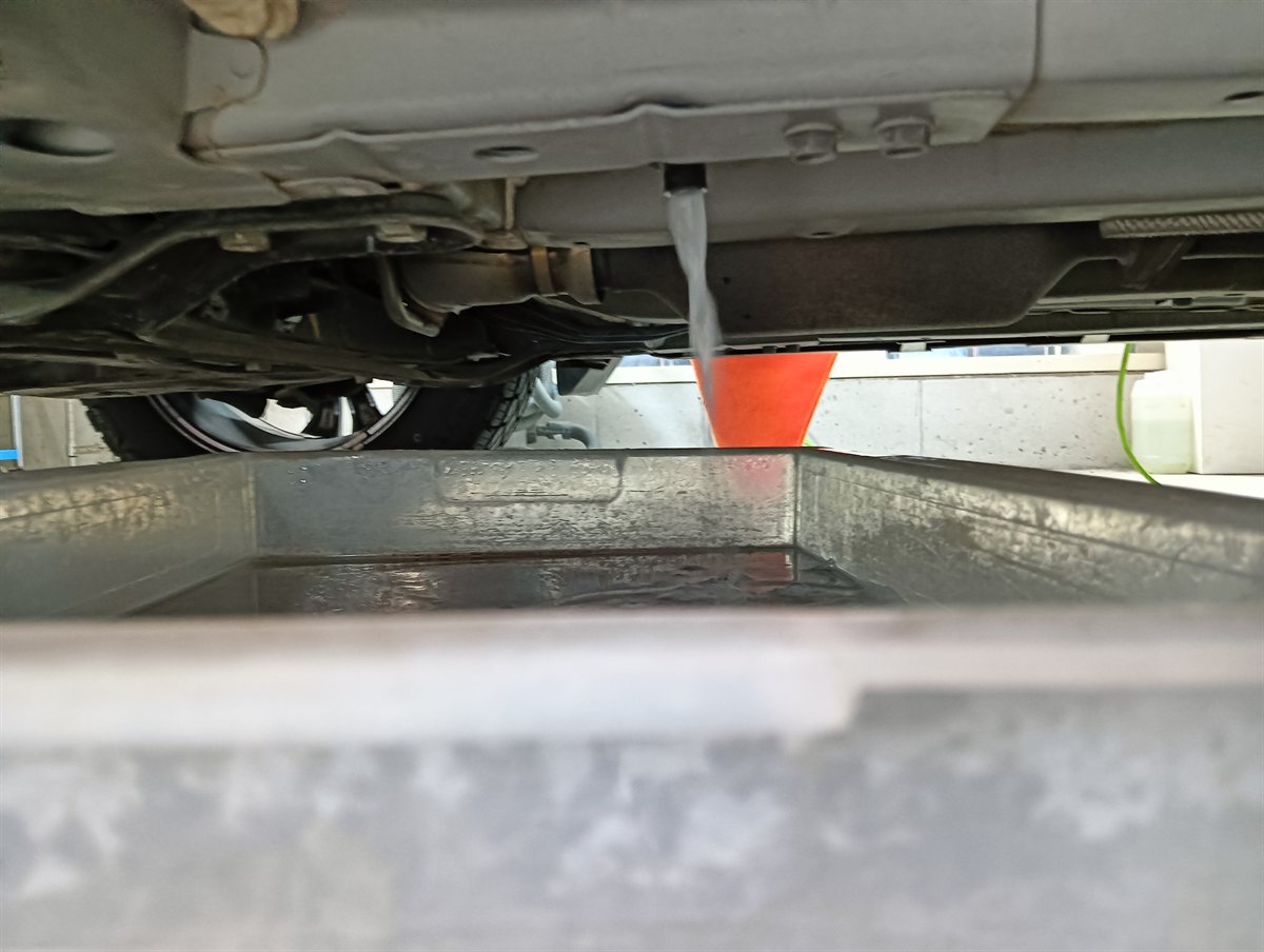 エバポレーターを洗った水を車の下で受けているところ